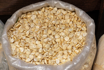 A close-up shot of white hominy kernels inside a plastic bag at market stall.