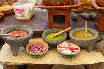 Close up of Assorted Colorful Salsa and Condiments in Stone Bowl at street food stall.