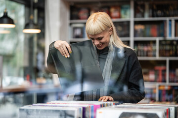 Young woman enjoying record shopping at music store