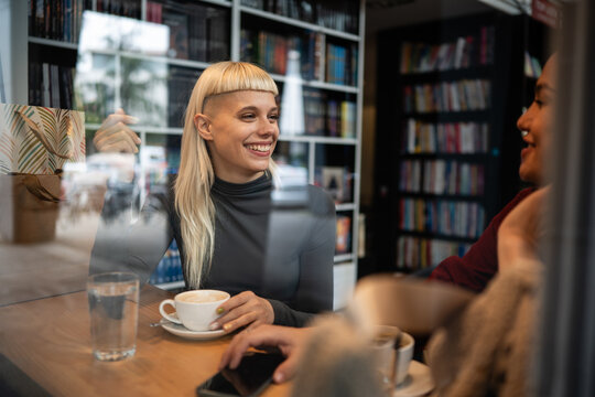 Friends enjoying coffee and conversation in bookstore cafe