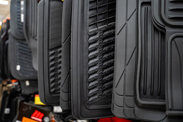 Close up of black rubber car floor mats on display.