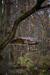 Handmade wooden birdhouse on a tree in the forest. Rustic made of natural wood and branches