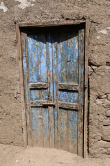 Weathered blue door on an Egyptian mud brick building