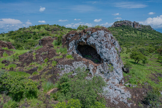 Aerial view of the Napedet cave, amidst the lush, green landscape, Pian Upe Game Reserve, Moroto, Uganda.