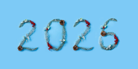 Numbers 2026 made from Christmas tree branches, cones and red berries. New Year calendar
