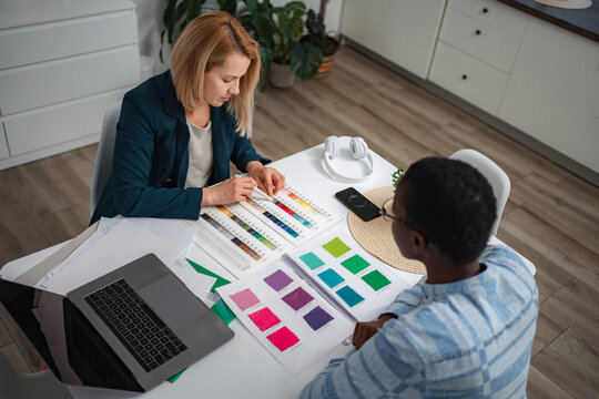 Women collaborating on interior design choosing color swatches