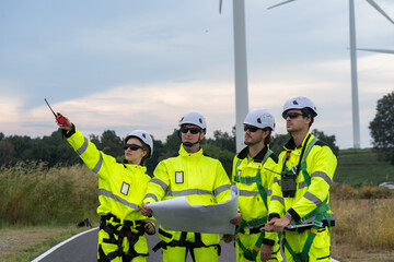 Field engineers examine wind turbine layout plans amid open-air wind power sources, symbolizing...