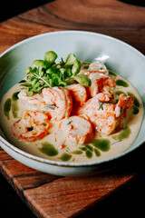 Delicious shrimp dish served in creamy sauce with fresh herbs and greens