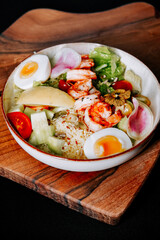 Scrumptious shrimp salad with fresh vegetables on a wooden serving board