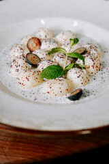 Delicious creamy dessert with fruit and mint served in a white bowl