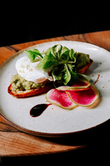 Gourmet toast with creamy topping and fresh greens served on minimalist plate