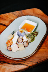 Gourmet cheese platter with fresh herbs and honey on a rustic wooden board