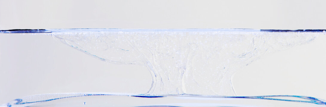 Side cut image of water with bubbles and splashes in a container