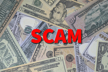 Background of US currency overlaid with word SCAM in red