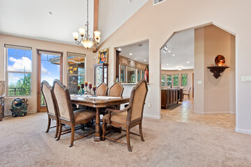 A dining room with a table, chairs, and a chandelier above