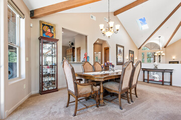 A dining room with a table, chairs, and a chandelier above