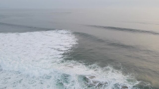 Aerial view of the powerful ocean waves crashing against the shore, creating a mesmerizing display of raw energy and natural beauty, Costa da Caparica, Setubal, Portugal.