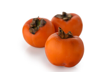 Three appetizing persimmons on white background