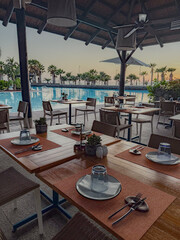 Resort restaurant creating tropical poolside dining experience at sunset