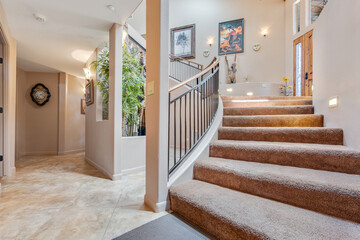 A staircase with a curved railing and carpeted floor in a house