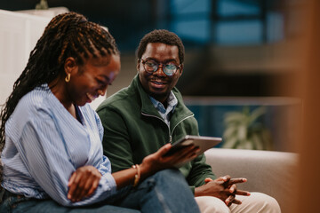 Young black colleagues discussing work using tablet