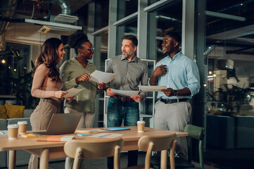 Diverse startup team collaborating during late night meeting