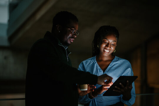 Business colleagues collaborating on tablet late at night - Powered by Adobe