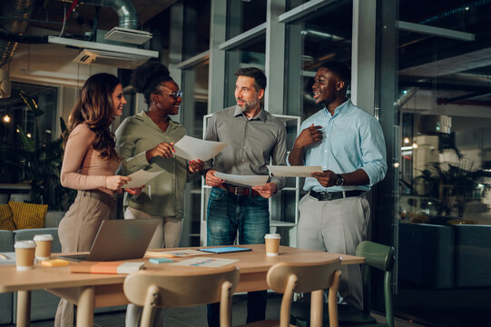 Diverse startup team collaborating during late night meeting