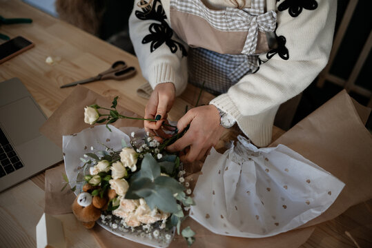 Woman florist crafting beautiful rose bouquet