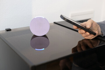 person controls smart wireless device with cell phone at home