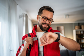 Fototapeta premium Paramedic man checking smartwatch during home visit consultation