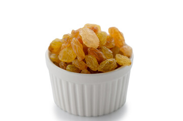 White bowl filled with golden raisins on white background