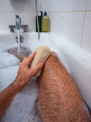 Washing foot with sponge in relaxing bath
