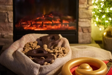 Cozy Holiday Scene. A warm fireplace with festive decorations and treats, including nuts and chocolate letters,
