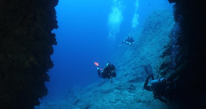 scuba divers are swimming through a channel underwater 