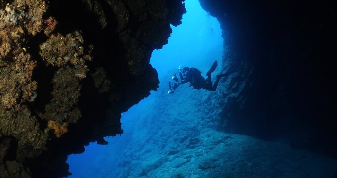 scuba divers are swimming through a channel underwater 