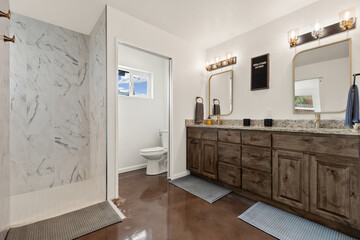 A bathroom that includes a toilet, a sink, a mirror, and a walkin shower space