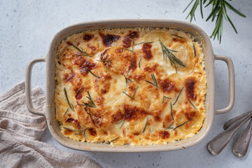 Creamy potato gratin topped with golden cheese and fresh herbs baked to perfection in a rustic dish