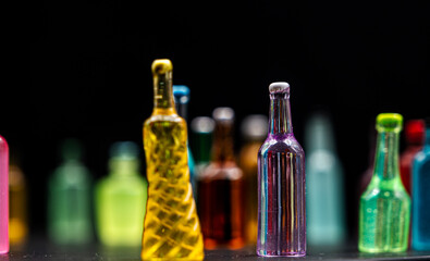 various miniature bottles of alcohol without labels with black bacground