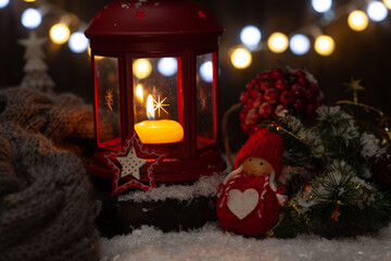 Warm candlelight decorates a festive winter scene with greenery and ornaments during the holiday season