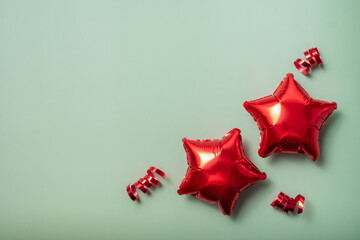 Red star-shaped balloons on a light green background for celebrations and parties