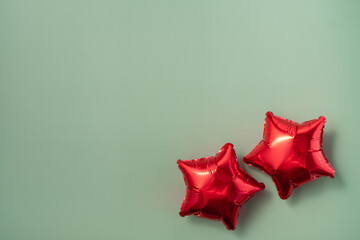 Red star-shaped balloons on a light green background for celebrations and parties