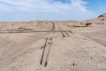 Train tracks which were used for excavations, railway tracks stretch into a barren landscape in Uruk, Iraq
