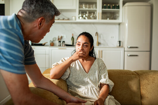 Mature father comforting adult daughter in sad conversation at home kitchen