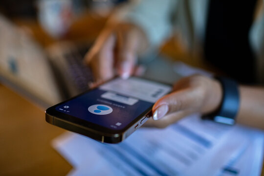 Focused adult using smartphone for mobile payment at home office desk - Powered by Adobe