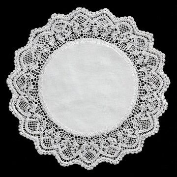Round white lace doily on black background close up