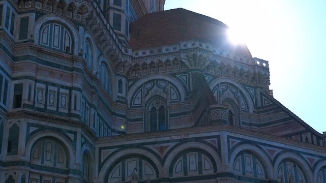 Sunlight reflecting on santa maria del fiore cathedral in florence. Warm sunlight gleaming across ornate marble dome of santa maria del fiore cathedral, producing soft lens flare against blue sky