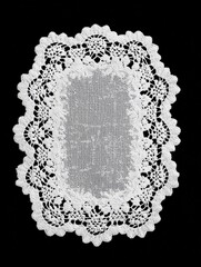 Rectangular white lace doily with scalloped border on black background