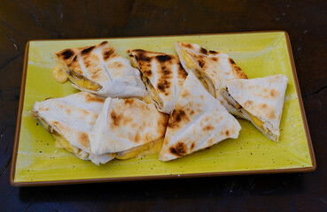 Grilled quesadillas on wooden board and with salsa and guacamole on stone background. Mexican cuisine concept Quesadilla wrap with chicken and corn. Top view. High quality photo