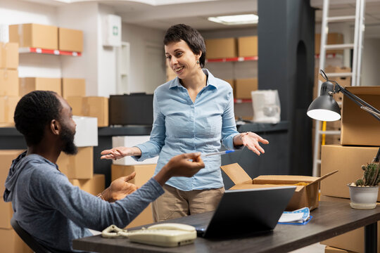 Diverse team checking order logistics for small business in house operations, small scale warehouse activity to ensure import export and distribution. Delivery service and inventory control.